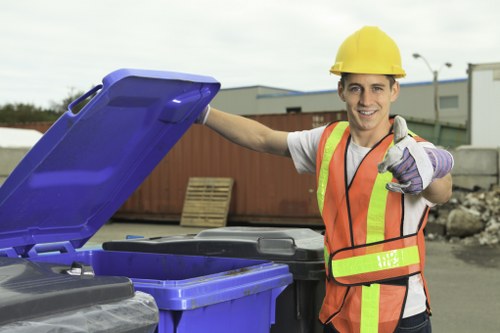 Operator sorting business rubbish into labelled containers